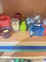 Shelf showing candle holders, Permalite bulb box and light-bulb packs