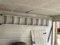 ladder hung horizontally on garage wall showing full length and rungs