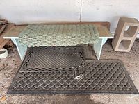 Bench with three mats placed on and under it, plus cinder block to right