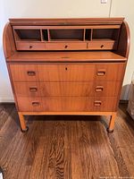 Full front view of roll-top desk showing drawers, legs, overall design