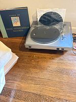 Samsung USB turntable with dust cover beside vinyl records