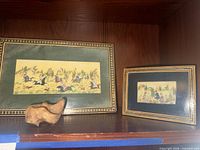 Both framed artworks and decorative rock on shelf