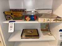 Shelf view showing Crayola, chalk, Playskool toy, mattress cover box, cigar box