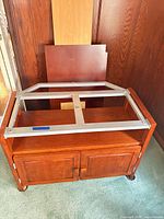 Front view of wood TV cabinet with metal frame on top