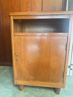Front view showing cabinet door, open cubby, feet, hardware
