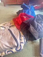 Five of the six folded jackets showing variety of colors and materials