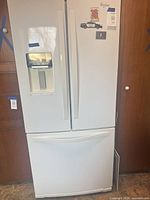Full view of white Whirlpool French door refrigerator with bottom freezer