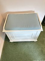 White wood bench with blue cushion closed view