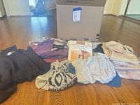 All clothing and packaged shapewear laid out with shipping box