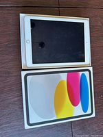 Front view of iPad in box alongside lid
