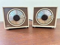 Front view of both timers showing dials, housings and branding