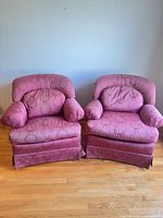 Both matching rose damask skirted armchairs front view