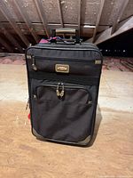 Front view showing brand plaque, zip pockets, corner accents