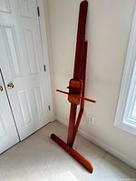 Full view of folded wooden studio easel against wall