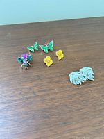 Group view of brooch and three earring pairs
