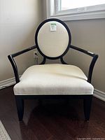 Front view of chair showing black frame and off-white upholstery