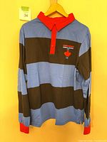 Front view of blue-black striped rugby jersey on hanger