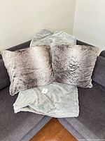 Pillows and blanket displayed on sofa