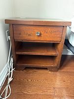Nightstand front view showing drawer, two shelves, finish wear