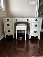 Front view of white painted vanity with stool inserted