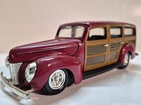 Front three-quarter view showing maroon paint, wood panels, chrome bumper, wheels