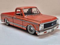 Front three-quarter view of orange 1972 Chevrolet Cheyenne die-cast pickup