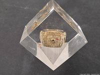 Ring encased in clear glass cube, full view