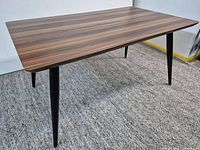 Full view of dining table showing walnut top and black legs