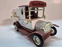 Front three-quarter view showing gold-tone radiator, open cab, Good Humor sign on roof