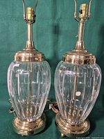 two clear ribbed glass lamps with brass bases and harps