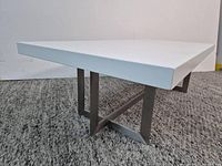 Three-quarter view showing tabletop thickness and chrome base structure