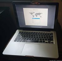 MacBook Pro open and powered on showing welcome screen