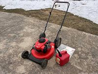 Front view of red Craftsman push mower, fuel can, manuals