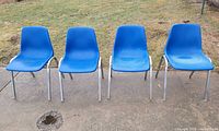 Front view of four blue HON stacking chairs on patio