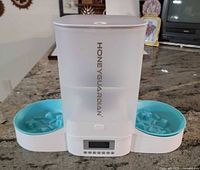 Front view of feeder showing hopper, dual bowls, control panel