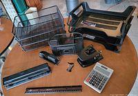 all items laid out, showing trays, punches, stapler, calculator