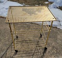 Full view of brass rolling bar cart on casters