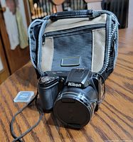 Camera front with lens cap, case behind, microSD card visible