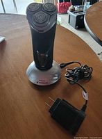 Shaver on charging stand with AC adapter visible