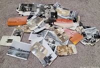 Overview of pile of assorted vintage photographs on carpet