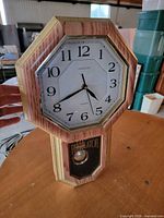 Front view of Herloon regulator clock showing dial and case