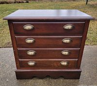 Front view showing four drawers and brass-tone pulls