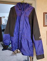 Full front view of royal blue and black North Face jacket hanging