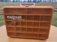 Front view showing Magnum by Plano logo and clear amber lid with compartment grid visible