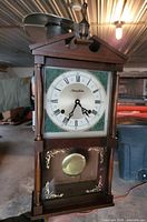 Full view of the Phinney-Walker pendulum wall clock showing wooden case, finial and brass pendulum