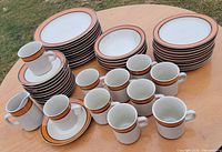 overall view of stacked plates, bowls, oval platters and mugs showing pattern and quantity