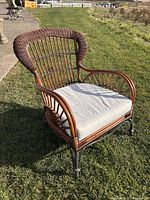Front angled view of wicker arm chair on grass