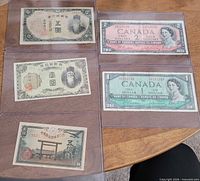 All five banknotes in sleeves showing fronts