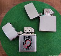 Both Zippo lighters open showing inserts