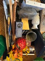 Box view showing assorted items including Game of Thrones box, ceramic vases, red strawberry jar, artificial flowers